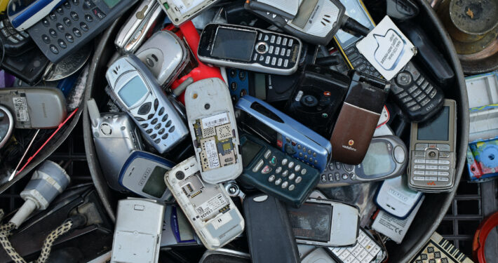 old and outdated Nokia, Alcatel, Siemens, Sony, Erricson cellphones in an unorganized pile